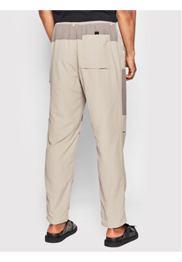 New Balance Spodnie materiałowe MP21502 Beżowy Relaxed Fit. Kolor: beżowy. Materiał: materiał, syntetyk