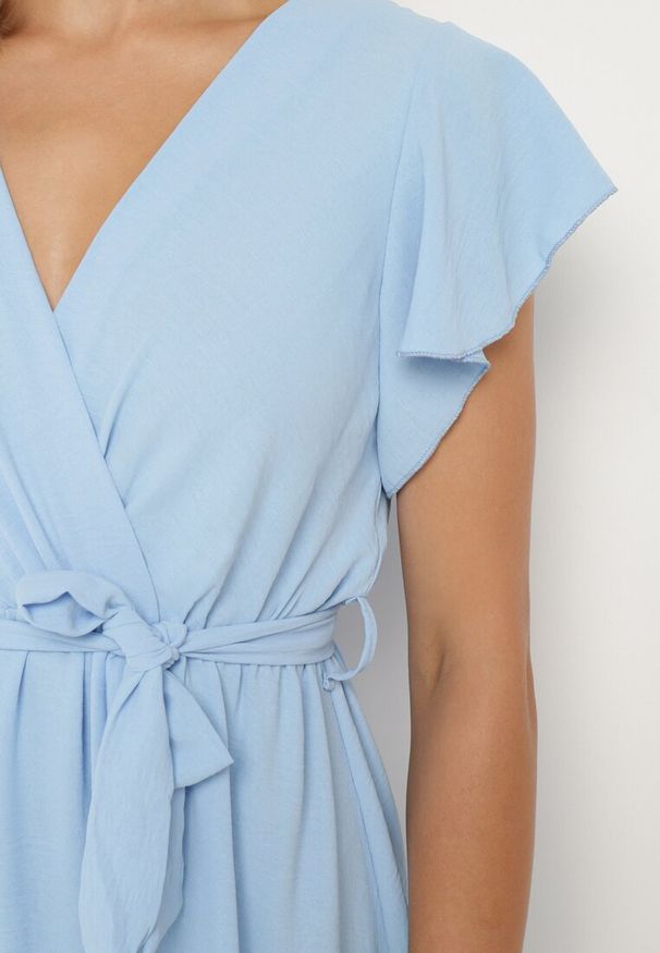 Born2be - Jasnoniebieska Kopertowa Sukienka z Asymetrycznym Dołem Ozdobiona Falbanką z Paskiem w Talii Snidia. Okazja: na spacer, na co dzień. Kolor: niebieski. Wzór: aplikacja. Sezon: lato. Typ sukienki: kopertowe, asymetryczne. Styl: elegancki, casual, klasyczny