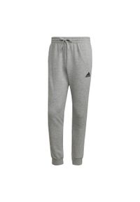 Adidas - Essentials Fleece Regular Tapered Pants. Kolor: wielokolorowy, czarny, szary. Materiał: bawełna, poliester, materiał. Sport: joga i pilates