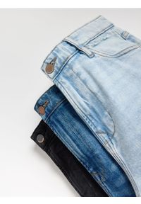 Reserved - Jeansy carrot slim z przetarciami - niebieski. Kolor: niebieski