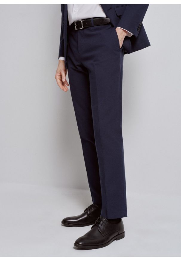 Ochnik - Granatowe spodnie garniturowe męskie. Kolor: niebieski. Materiał: bawełna