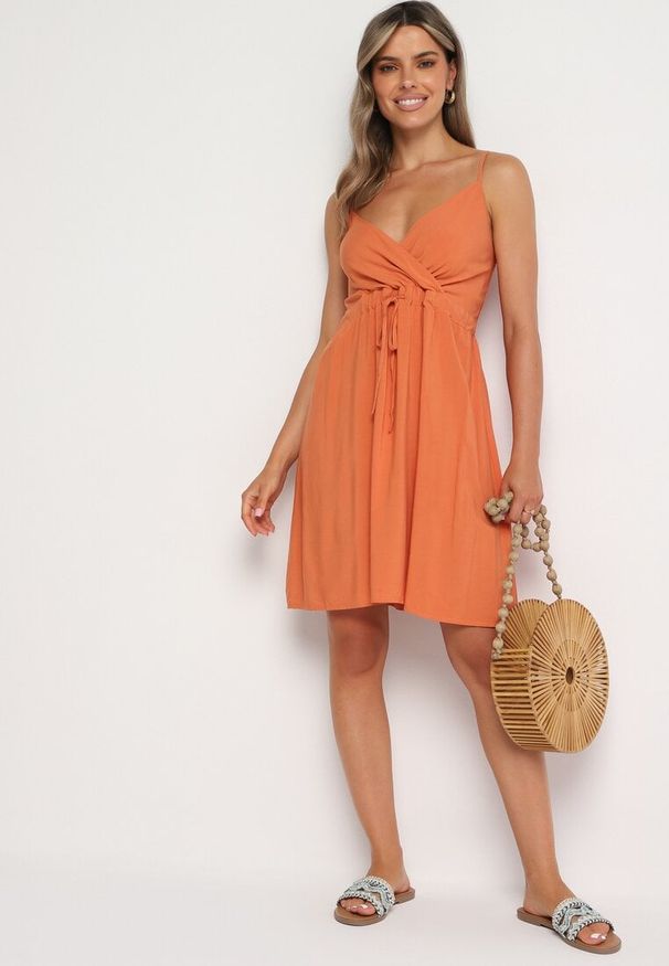 Born2be - Pomarańczowa Bawełniana Sukienka na Cienkich Regulowanych Ramiączkach z Kopertowym Dekoltem Pennea. Okazja: na co dzień. Typ kołnierza: dekolt kopertowy. Kolor: pomarańczowy. Materiał: bawełna. Długość rękawa: na ramiączkach. Typ sukienki: kopertowe. Styl: elegancki, sportowy, casual