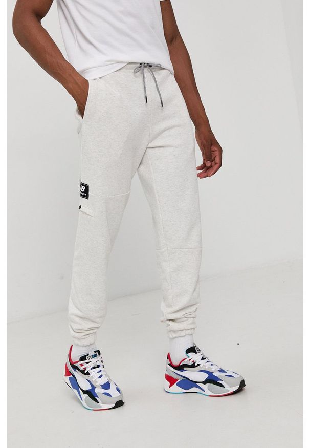 New Balance Spodnie męskie kolor szary gładkie. Kolor: szary. Materiał: dzianina. Wzór: gładki