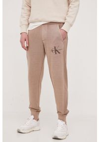 Calvin Klein Jeans spodnie dresowe bawełniane kolor brązowy gładkie. Kolor: brązowy. Materiał: bawełna, dresówka. Wzór: gładki #1