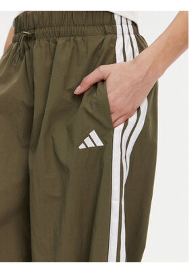 Adidas - adidas Spodnie dresowe Essentials 3-Stripes JE1308 Zielony Loose Fit. Kolor: zielony. Materiał: syntetyk