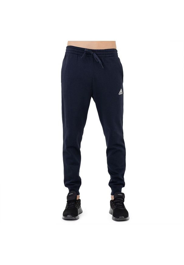 Adidas - Spodnie adidas Essentials Fleece Regular Tapered HL2231 - granatowe. Kolor: niebieski. Materiał: dresówka, tkanina, poliester, bawełna