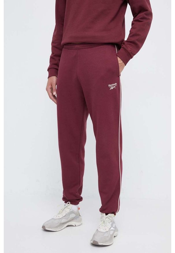 Reebok spodnie dresowe kolor bordowy gładkie. Kolor: czerwony. Materiał: dresówka. Wzór: gładki
