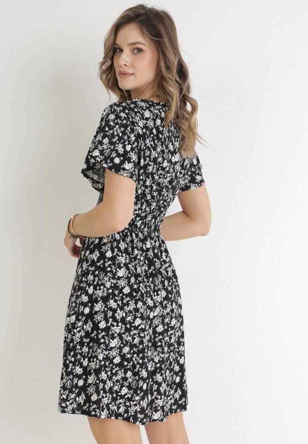 Born2be - Czarna Kwiecista Sukienka Mini z Wiskozy z Marszczoną Gumką w Pasie Catela. Kolor: czarny. Materiał: wiskoza. Długość rękawa: krótki rękaw. Wzór: kwiaty. Sezon: wiosna, lato. Typ sukienki: rozkloszowane, kopertowe. Długość: mini