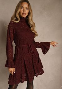 Renee - Bordowa Sukienka ze Stójką z Koronki Zdobiona Wiązaniem w Talii i Falbanami Elarassa. Typ kołnierza: kołnierzyk stójkowy. Kolor: czerwony. Materiał: koronka. Długość rękawa: na ramiączkach. Wzór: koronka, aplikacja. Styl: rockowy #1