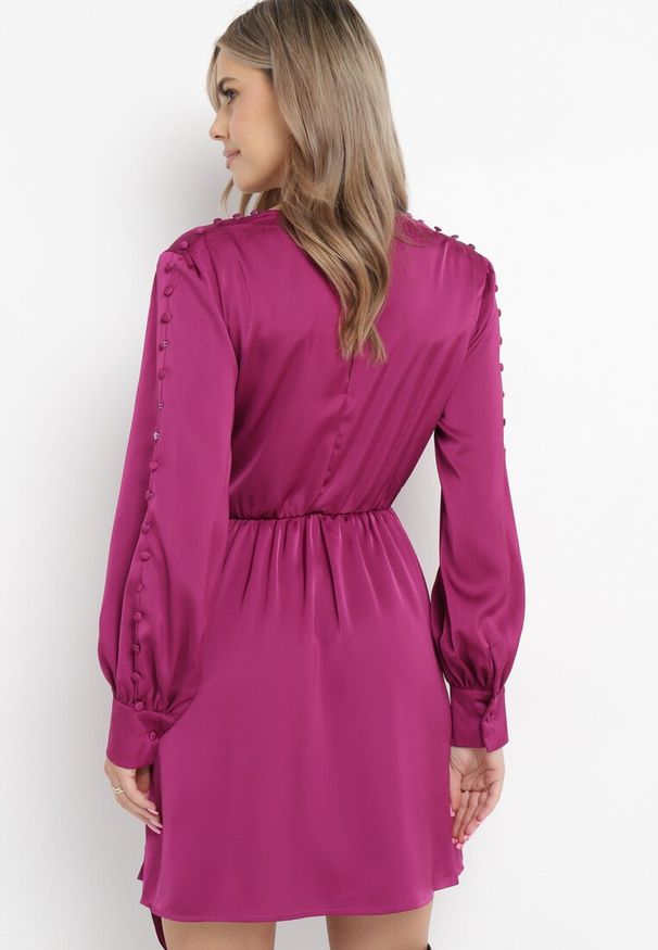 Born2be - Fuksjowa Sukienka z Gumką w Pasie z Kopertowym Dekoltem i Paskiem z Metalową Klamrą Branica. Typ kołnierza: dekolt kopertowy. Kolor: różowy. Materiał: tkanina. Wzór: aplikacja. Typ sukienki: kopertowe
