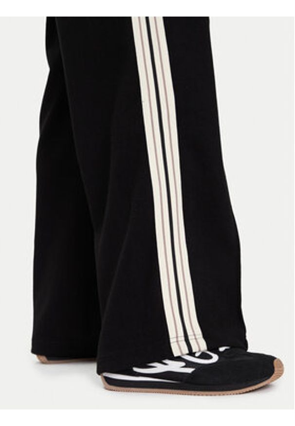 Guess Spodnie dresowe V5BB16 KCX52 Czarny Wide Leg. Kolor: czarny. Materiał: syntetyk