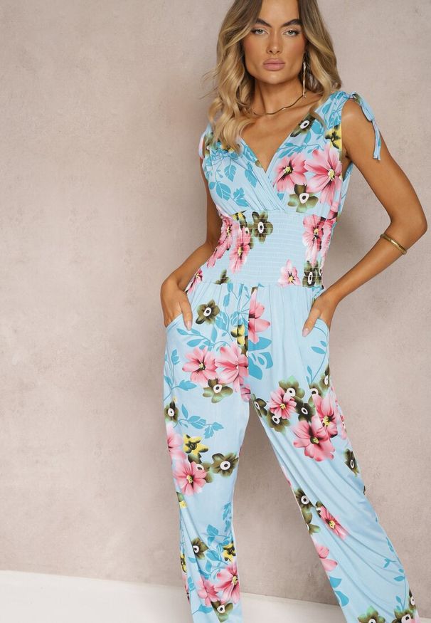 Renee - Jasnoniebieski Kombinezon z Ściągaczami na Ramionach w Kwiatowy Wzór Almora. Okazja: na imprezę, na co dzień. Kolor: niebieski. Wzór: kwiaty. Sezon: lato. Styl: elegancki, casual, klasyczny