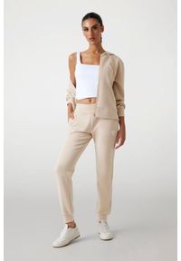 Guess - GUESS Spodnie damskie dresowe w kolorze taupe Olympe. Kolor: beżowy. Materiał: dresówka #3