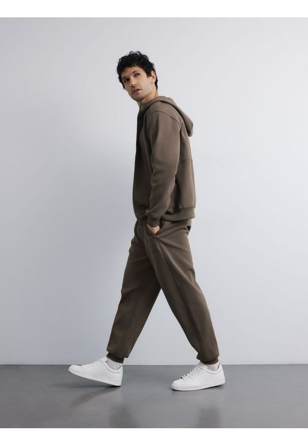 Reserved - Spodnie dresowe comfort fit - jasny zielony. Kolor: zielony. Materiał: dresówka