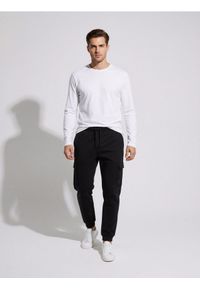 Sinsay - Spodnie dresowe cargo - czarny. Kolor: czarny. Materiał: dresówka #1