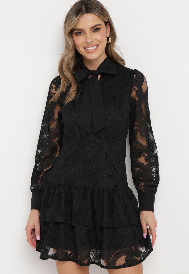 Born2be - Czarna Sukienka w Stylu Boho z Koronkowej Tkaniny Wiązana Przy Szyi Asavie. Typ kołnierza: kołnierz z falbankami. Kolor: czarny. Materiał: tkanina, koronka. Długość rękawa: długi rękaw. Styl: boho. Długość: mini