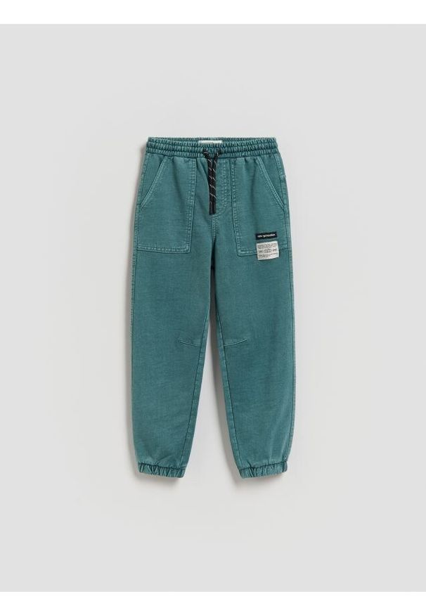 Reserved - Joggery z efektem sprania - morski. Kolor: morski. Materiał: dzianina, bawełna