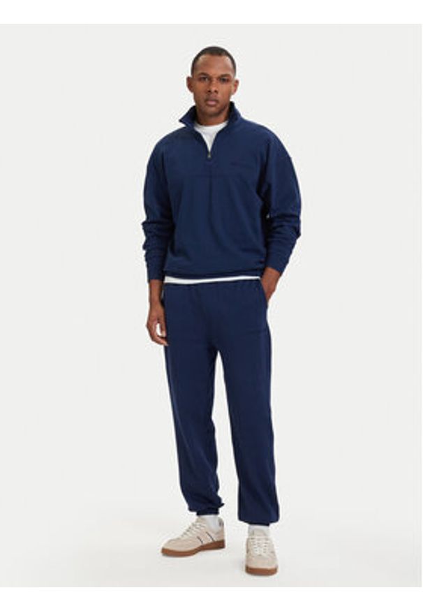 TOMMY HILFIGER - Tommy Hilfiger Spodnie dresowe Essential UM0UM03911 Granatowy Relaxed Fit. Kolor: niebieski. Materiał: bawełna
