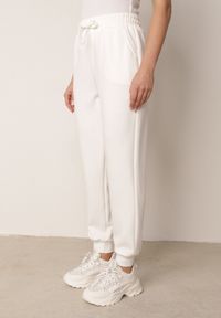 Born2be - Białe Spodnie Dresowe Joggery z Wysokim Stanem i Ściągaczami przy Kostkach Janlea. Okazja: do domu, na co dzień, na spacer. Stan: podwyższony. Kolor: biały. Materiał: dresówka. Długość: krótkie. Styl: sportowy, klasyczny, casual #6
