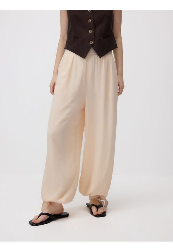 Reserved - Spodnie jogger z wiązaniem - brzoskwiniowy. Kolor: pomarańczowy. Materiał: tkanina