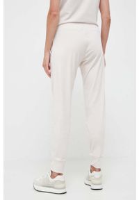 DKNY - Dkny spodnie dresowe kolor beżowy gładkie. Kolor: beżowy. Materiał: dresówka. Wzór: gładki #4