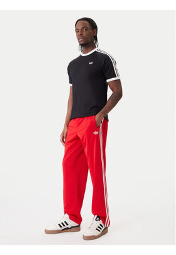 Adidas - adidas Spodnie dresowe Firebird KD8319 Czerwony Loose Fit. Kolor: czerwony. Materiał: syntetyk