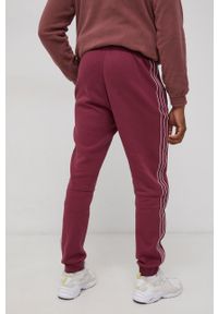 adidas Originals Spodnie męskie kolor fioletowy gładkie. Kolor: fioletowy. Materiał: poliester, bawełna. Wzór: gładki