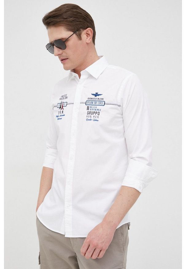 Aeronautica Militare koszula męska kolor biały slim z kołnierzykiem klasycznym. Typ kołnierza: kołnierzyk klasyczny. Kolor: biały. Materiał: tkanina. Wzór: aplikacja. Styl: klasyczny