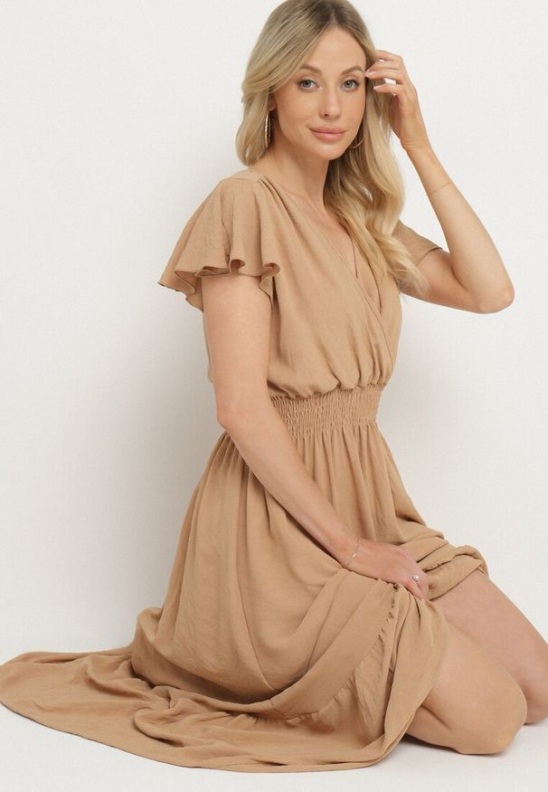Born2be - Beżowa Sukienka o Rozkloszowanym Kroju z Kopertowym Dekoltem i Gumką w Talii Reiliana. Okazja: na co dzień, na imprezę. Typ kołnierza: dekolt kopertowy. Kolor: beżowy. Typ sukienki: kopertowe. Styl: casual, elegancki