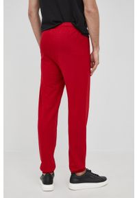 Lacoste Spodnie męskie kolor czerwony z nadrukiem. Kolor: czerwony. Materiał: dzianina. Wzór: nadruk