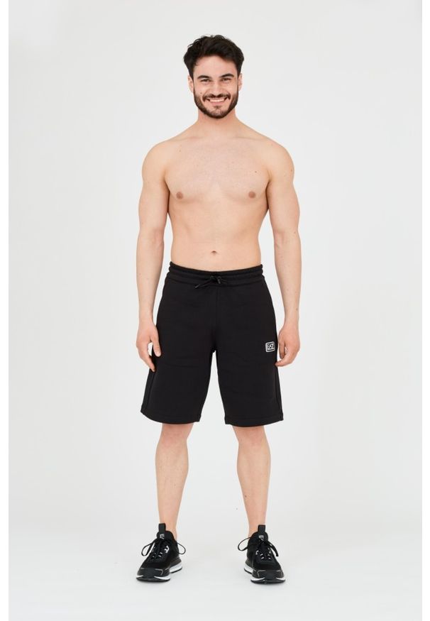 EA7 Emporio Armani - EA7 Męskie czarne krótkie spodenki z naszywkę. Kolor: czarny. Materiał: bawełna. Długość: krótkie. Wzór: aplikacja