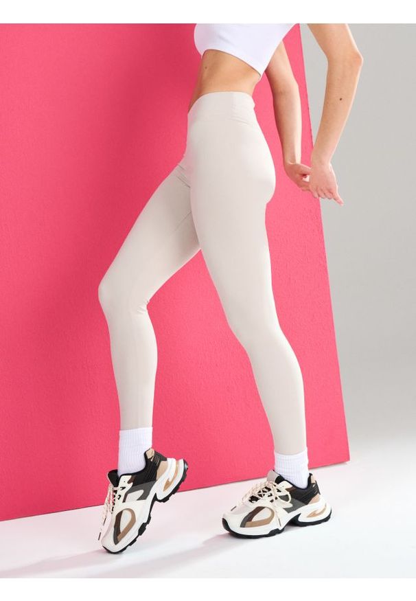 Sinsay - Sportowe legginsy z wycięciem V w talii Gym Hard - kremowy. Kolor: kremowy. Styl: sportowy