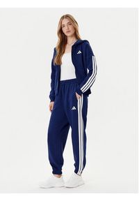 Adidas - adidas Spodnie dresowe Essentials 3-Stripes Fleece JX7696 Niebieski Loose Fit. Kolor: niebieski. Materiał: syntetyk #5