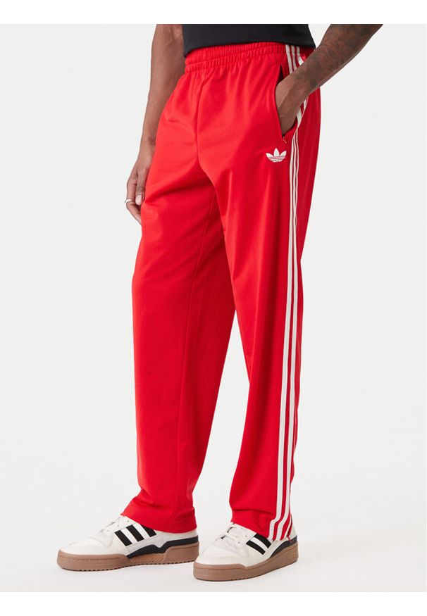 Adidas - adidas Spodnie dresowe Firebird KD8319 Czerwony Loose Fit. Kolor: czerwony. Materiał: syntetyk