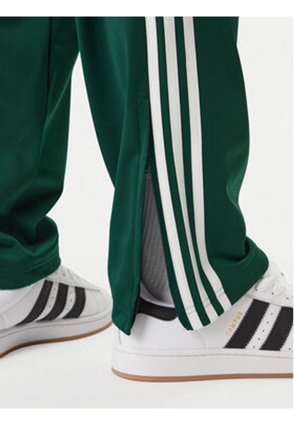 Adidas - adidas Spodnie dresowe Firebird KD8317 Zielony Loose Fit. Kolor: zielony. Materiał: syntetyk