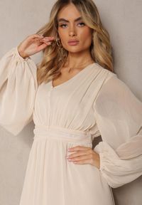 Renee - Beżowa Plisowana Sukienka Koktajlowa Ozdobiona Guzikami i Falbankami Osumia. Typ kołnierza: kołnierz z falbankami. Kolor: beżowy. Długość rękawa: długi rękaw. Wzór: aplikacja. Sezon: lato, wiosna. Typ sukienki: rozkloszowane. Styl: wizytowy