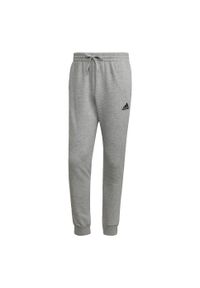 Adidas - Essentials Fleece Regular Tapered Pants. Kolor: szary, czarny, wielokolorowy. Materiał: bawełna, poliester, materiał. Sport: joga i pilates, fitness