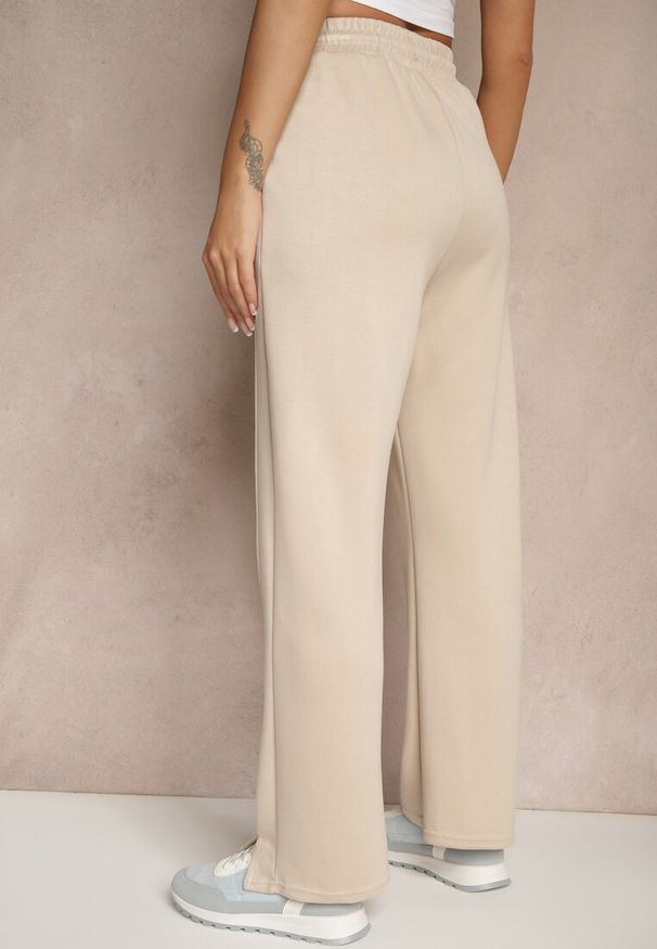 Renee - Beżowe Szerokie Spodnie Dresowe High Waist Ozdobione Sznurkiem Haliran. Okazja: na co dzień, na spacer. Stan: podwyższony. Kolor: beżowy. Materiał: dresówka. Wzór: aplikacja. Styl: elegancki, casual