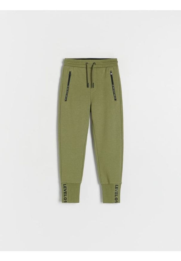 Reserved - Sportowe joggery - oliwkowy. Kolor: oliwkowy. Materiał: dresówka, bawełna, dzianina. Wzór: gładki. Styl: sportowy