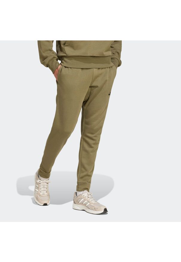 Adidas - Spodnie dresowe męskie ADIDAS Essentials Feelcozy. Kolor: zielony. Materiał: dresówka. Sport: joga i pilates