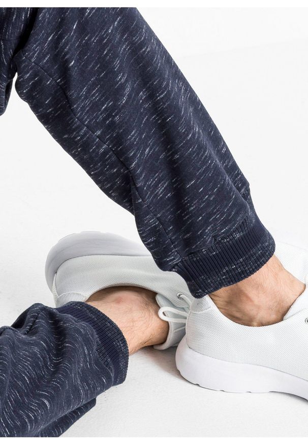 bonprix - Melanżowe spodnie sportowe ze ściągaczem. Kolor: niebieski. Wzór: melanż, prążki. Styl: sportowy