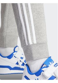 Adidas - adidas Spodnie dresowe adicolor 3-Stripes IM9318 Szary Slim Fit. Kolor: szary. Materiał: bawełna