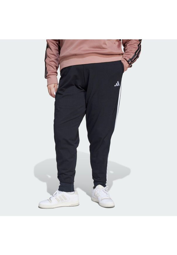 Adidas - Spodnie Dresowe Essentials 3-Stripes (Dla Sylwetek Plus Size). Kolekcja: plus size. Kolor: czarny, biały, wielokolorowy. Materiał: dresówka. Sport: fitness