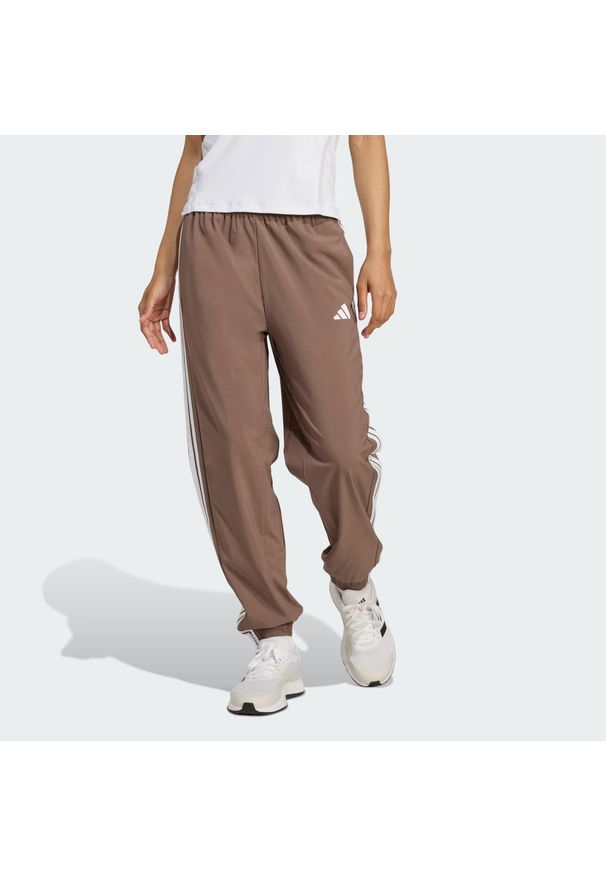 Adidas - Spodnie Train Essentials 3-Stripes Woven. Kolor: wielokolorowy, biały, beżowy, brązowy. Materiał: materiał. Technologia: ClimaCool (Adidas). Sport: fitness