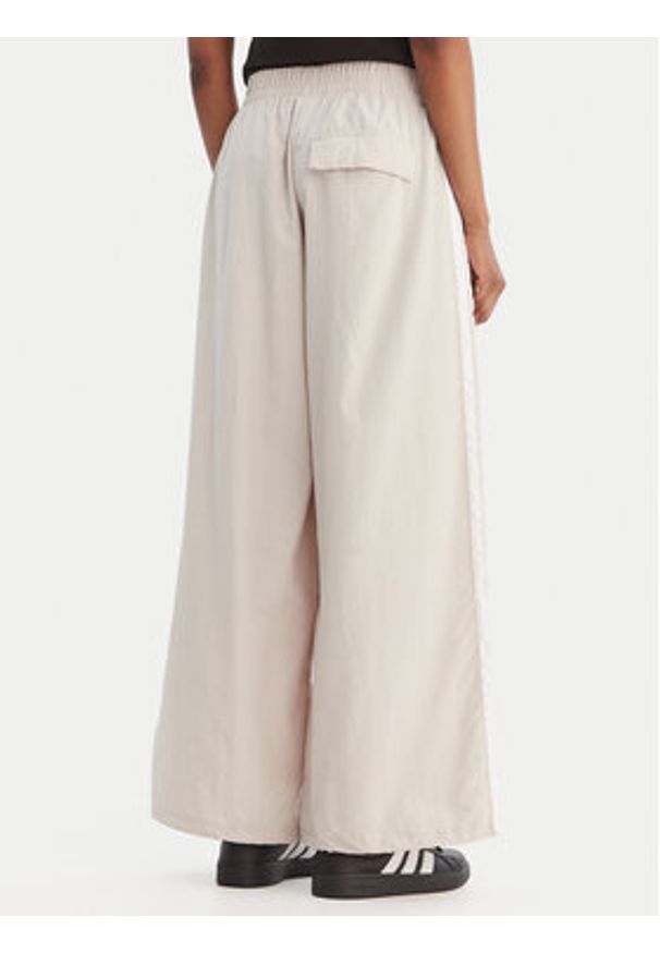 Adidas - adidas Spodnie dresowe Essentials 3-Stripes JC8168 Beżowy Loose Fit. Kolor: beżowy. Materiał: syntetyk