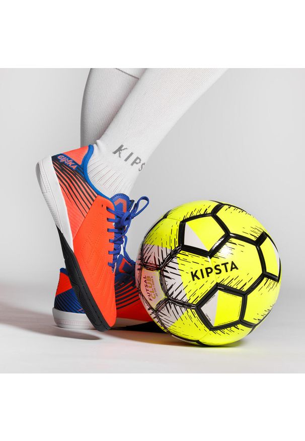 KIPSTA - Buty do piłki nożnej halowej dla dzieci Kipsta Ginka 500. Kolor: wielokolorowy, pomarańczowy, biały, czerwony, niebieski. Materiał: kauczuk. Wzór: gładki