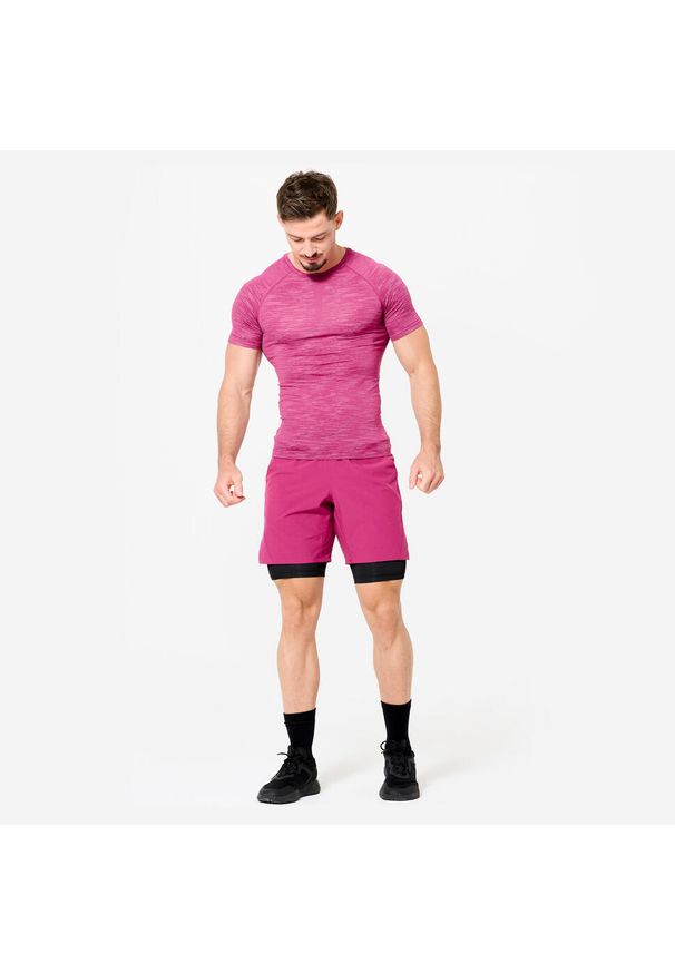DOMYOS - Spodenki fitness cardio męskie Domyos 2 w 1. Kolor: czarny, fioletowy, różowy, wielokolorowy. Materiał: materiał, elastan, poliester. Długość: krótkie. Sport: fitness