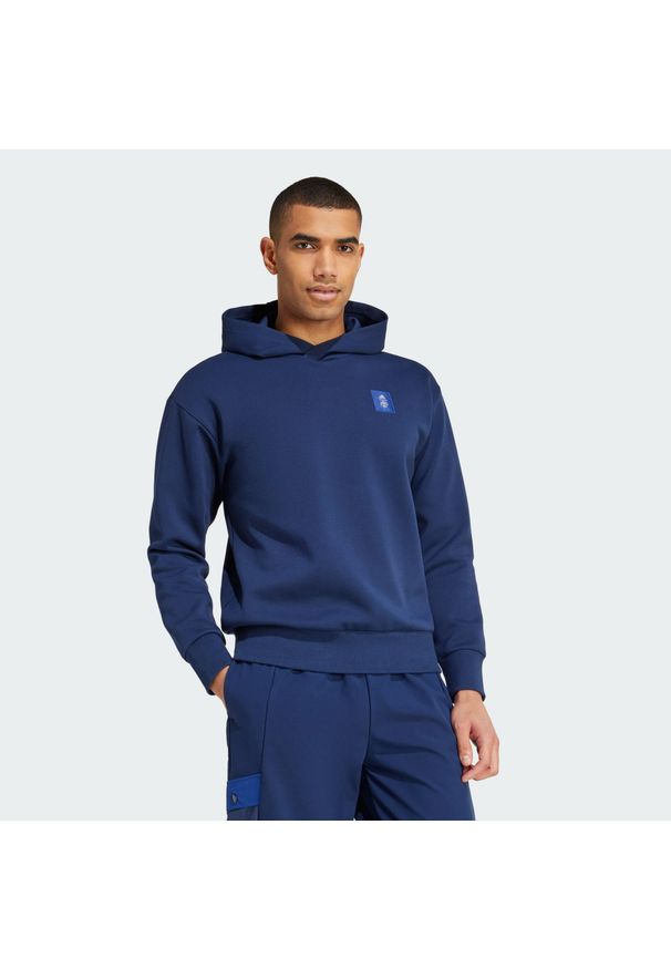 Adidas - Bluza z kapturem Manchester United Seasonal Doubleknit. Typ kołnierza: kaptur. Kolor: niebieski. Materiał: dzianina. Wzór: ze splotem. Sport: piłka nożna