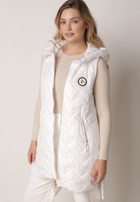 Born2be - Biała Przejściowa Kamizelka Pikowana o Długim Kroju z Kapturem i Naszywką Harmaste. Okazja: na co dzień. Typ kołnierza: kaptur. Kolor: biały. Materiał: jeans. Długość: długie. Wzór: aplikacja. Styl: casual #1