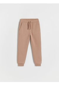 Reserved - Dresowe spodnie jogger - brązowy. Kolor: brązowy. Materiał: dresówka. Wzór: gładki #1